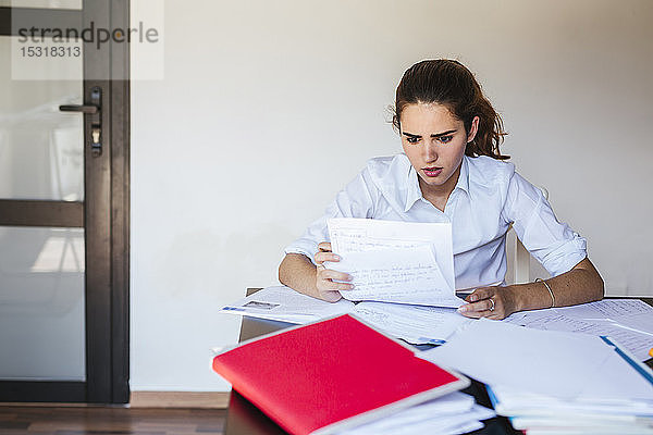 Schockierte Studentin liest Dokument am heimischen Schreibtisch