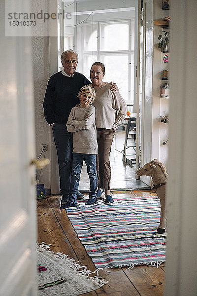 Porträt von glücklichen Großeltern mit Enkel zu Hause