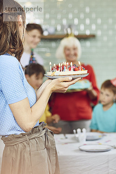 Mutter und Söhne feiern den Geburtstag ihrer Großmutter in ihrer Küche