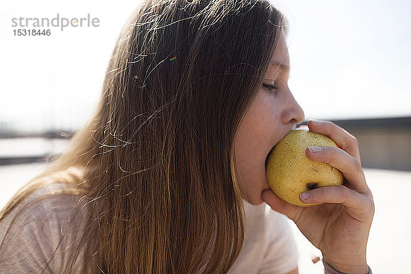 Mädchen isst einen Apfel im Freien