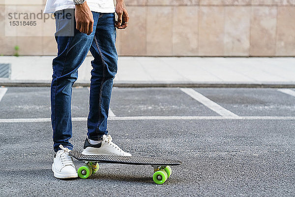 Beine eines jungen Mannes mit Skateboard