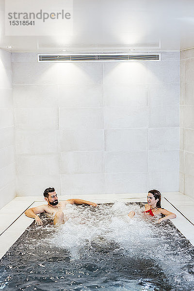 Mann und Frau genießen den Whirlpool in einem Spa