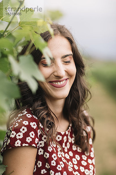 Porträt einer lachenden jungen Frau in den Weinbergen