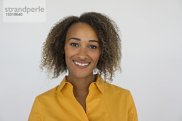 Porträt einer lächelnden jungen Frau mit gelbem Hemd