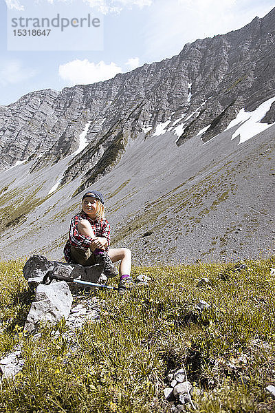 Mädchen macht während einer Wanderung in den Bergen eine Pause