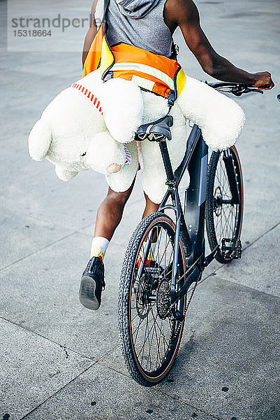 Fahrradkurier liefert einen Teddybär