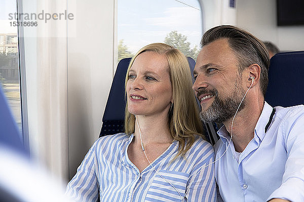 Ehepaar reist mit dem Zug und schaut aus dem Fenster