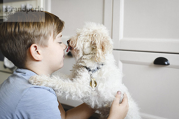 Junge spielt zu Hause mit seinem Hund
