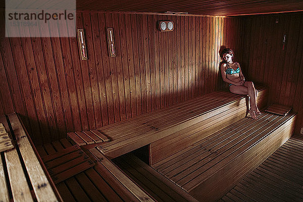 Junge Frau entspannt sich in der Sauna