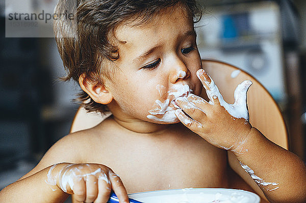 Kleiner Junge isst zu Hause Joghurt