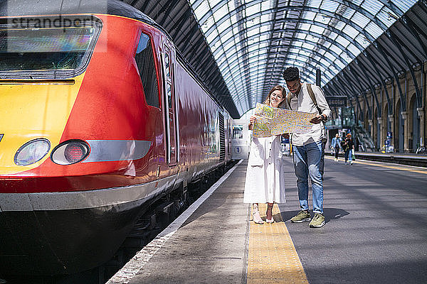 Junges Paar steht auf Plattform und schaut auf Karte  London  UK