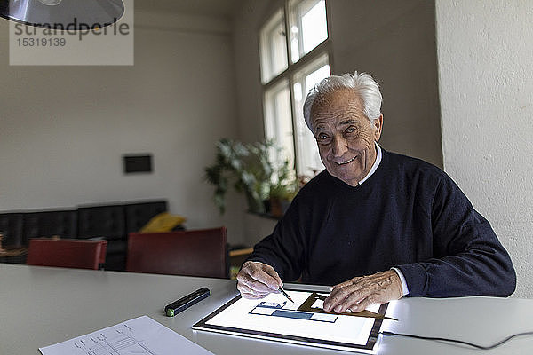 Porträt eines lächelnden älteren Mannes mit Tablett mit Architekturplan