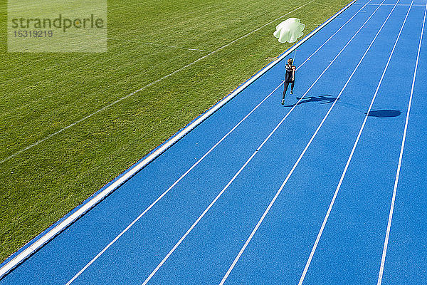Läuferin mit Fallschirm auf Tartanbahn