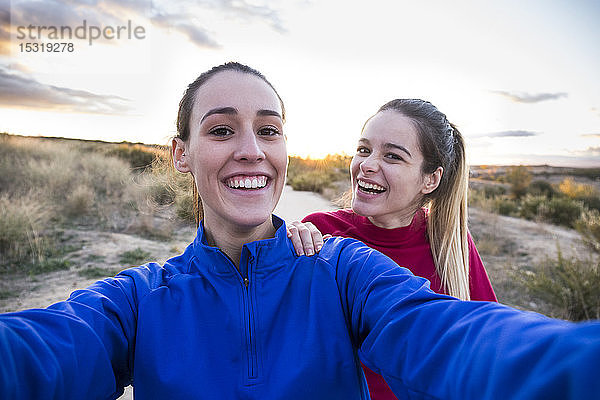 Junge Frauen in Sportkleidung nehmen Selfie mit Smartphone