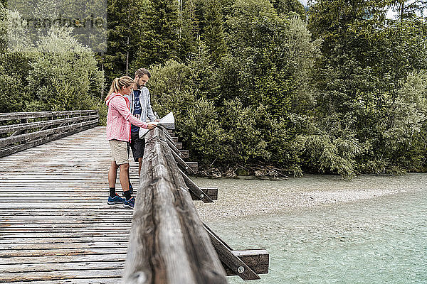 Junges Paar auf einer Wanderung beim Kartenlesen auf einer Holzbrücke  Vorderriss  Bayern  Deutschland