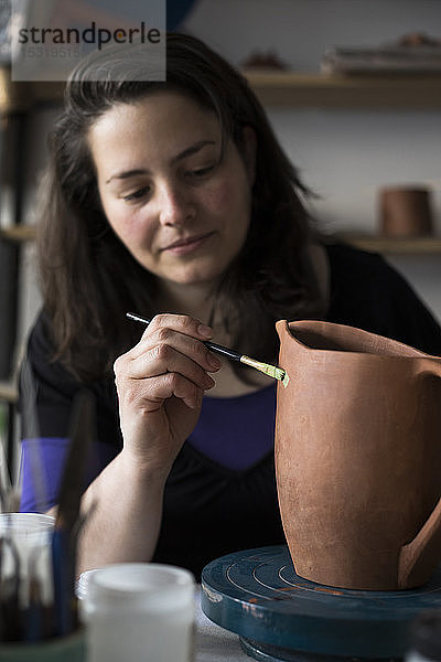 Töpferin bemalt unvollendete Vase in ihrer Werkstatt