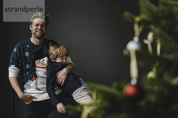 Vater und Sohn amüsieren sich gemeinsam zur Weihnachtszeit
