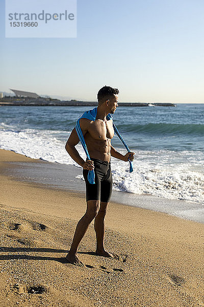 Sportlicher  barbusiger Mann am Strand