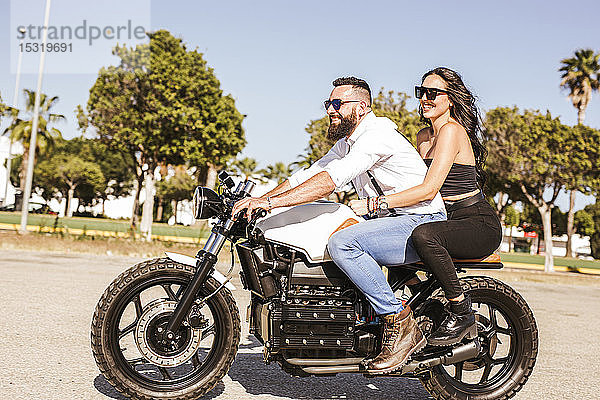 Glückliches Paar auf dem Motorrad im Sommer