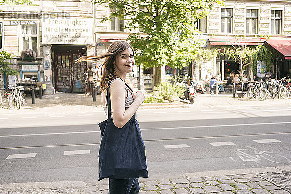 Porträt einer lächelnden jungen Frau auf der Straße in der Stadt