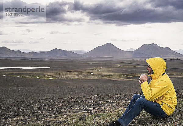 Erwachsener Mann macht eine Pause  trinkt Kaffee  Island