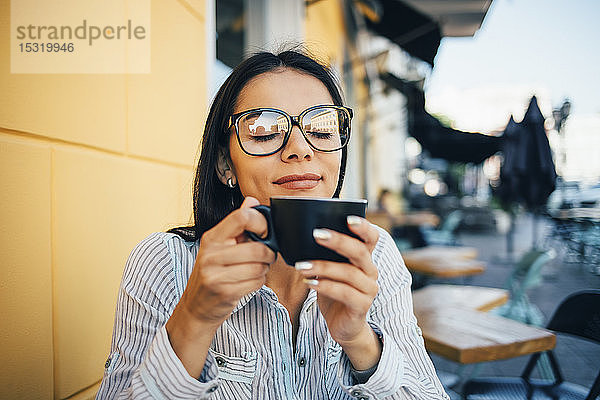 Junge Frau genießt eine Tasse Kaffee in einem Café