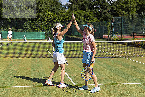 Glückliche reife Frauen feiern nach dem Tennisspiel