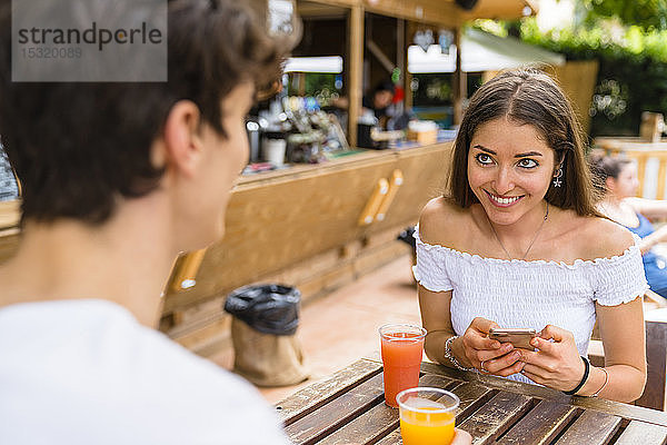 Junges Paar in einem Café  Frau benutzt Smartphone