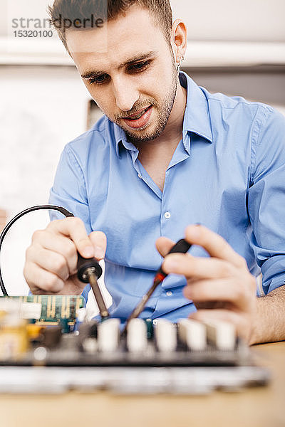 Techniker bei der Reparatur eines Desktop-Computers  Löten einer Komponente mit Zinn