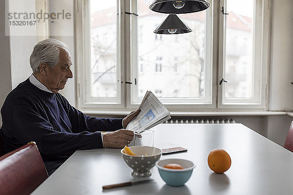 Älterer Mann liest zu Hause Zeitung