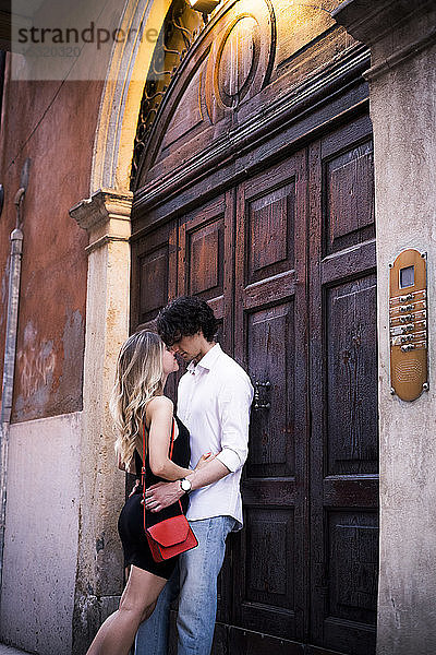 Zärtliches junges verliebtes Paar an einer Holztür in der Stadt
