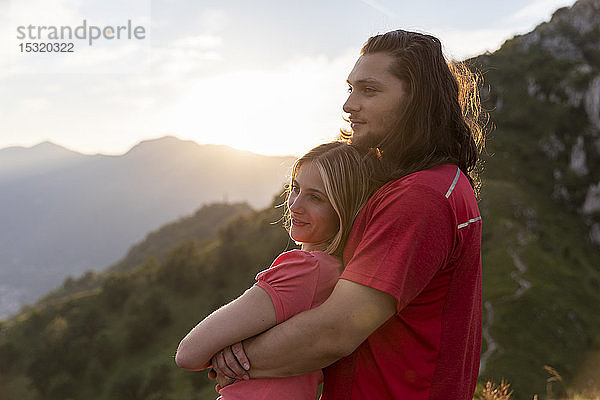 Junges Paar umarmt sich in den Bergen