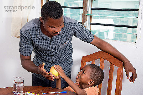 Dieses Kind zeigt seinem Vater den Apfel  weil es ihn essen möchte.