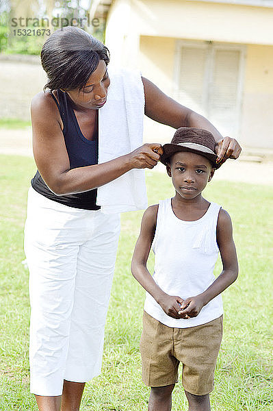 Diese junge Frau trägt einen Hut für ihren Sohn.