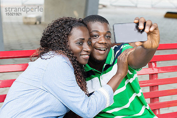 Ein junges Paar macht Fotos  um ihre Fahrt auf dem öffentlichen Platz zu markieren.
