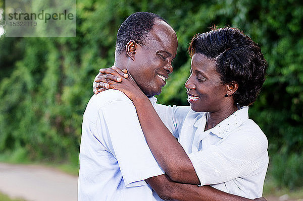glückliches junges Paar  das sich in der Kampagne von Angesicht zu Angesicht umarmt