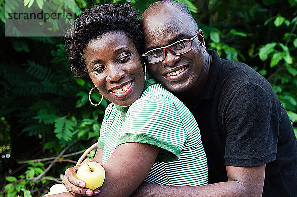 glückliches junges Paar  das sich beim Picknick im Busch umarmt