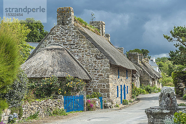 Frankreich  Bretagne  Nevez  'Pays des pierres debout' (Land der stehenden Steine)  Straße mit reetgedecktem Haus im Dorf Kercanic