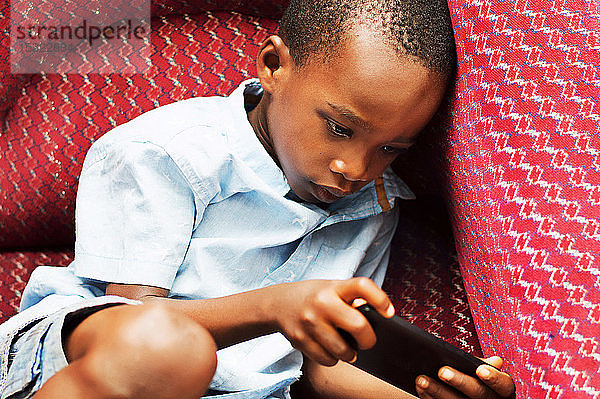 Dieses Kind ist sehr konzentriert auf sein Spiel im Handy.