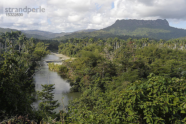 Kuba  Baracoa  eine Landschaft mit üppiger Vegetation  die vom Fluss Duaba durchflossen wird und von dem emblematischen Gipfel des Yunque überragt wird