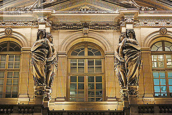 Paris. 1. Bezirk. Louvre-Museum bei Nacht. Platz im Innenhof. Fassade des Uhrenpavillons. Architektonisches Detail. Statue.