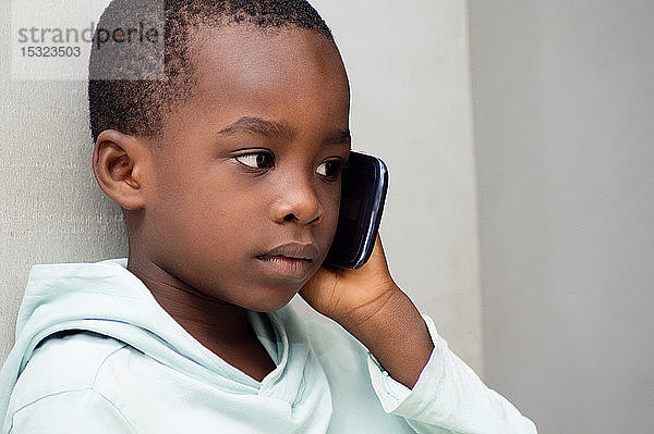 Das Kind hört mit großer Aufmerksamkeit zu  was ihm seine Mutter am Telefon erzählt.
