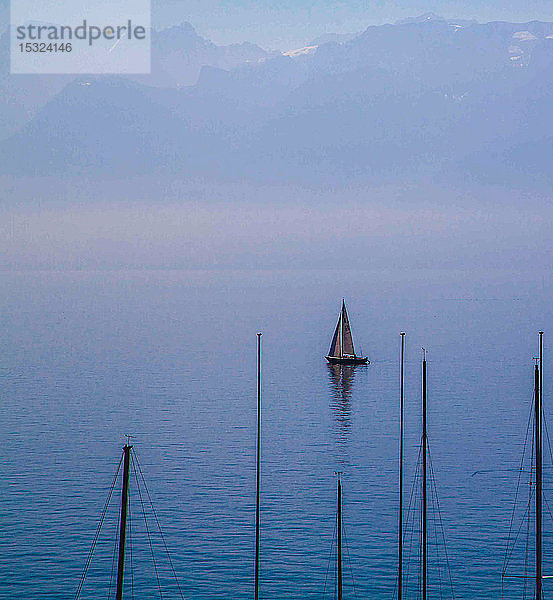 Segelboot auf dem Genfer See und Berge im Hintergrund