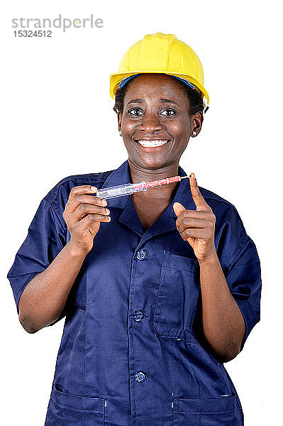 Eine lächelnde junge Frau zeigt ihr Arbeitsgerät.