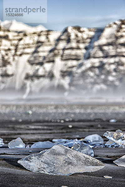 Island. Südöstliche Region. Jokulsarlon. Ein Eisblock  der an den vulkanischen Strand gespült wurde.