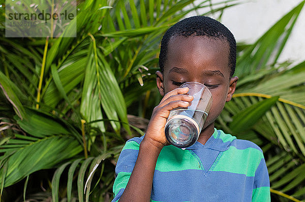 Junge trinkt Mineralwasser aus einem Glas.