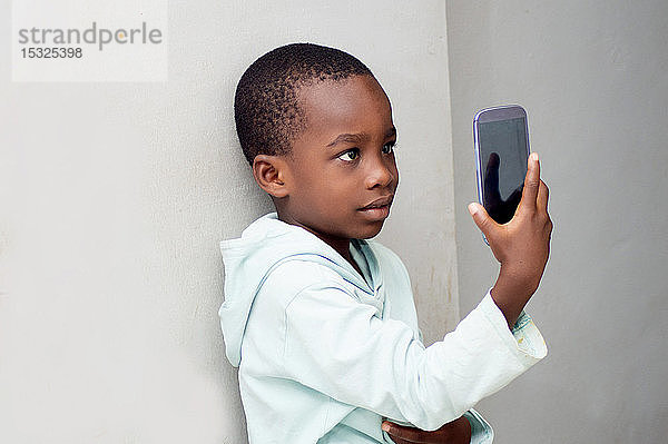 Ein kleiner Junge macht ein Foto mit seinem Handy.