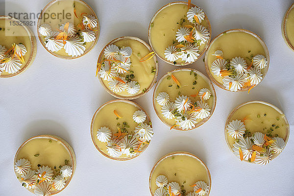 Zitronen-Passionsfrucht-Kuchen mit Baisertupfen und Blütenblättern