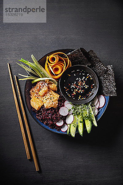 Sushi-Buddha-Schale mit rotem Reis  Lachs  Nori  Gemüse und Sojasauce