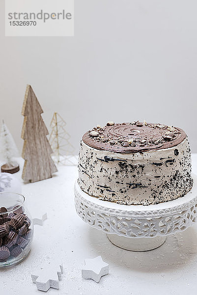Ein Schokoladenkuchen auf einem Kuchenständer auf einem weihnachtlich geschmückten Tisch